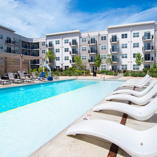 Swimming Pool pool with lounge chairs surrounded by trees and shrubbery
