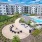 balcony view of outside courtyard, firepit, and resort-style pool showing ample seating and landscaping